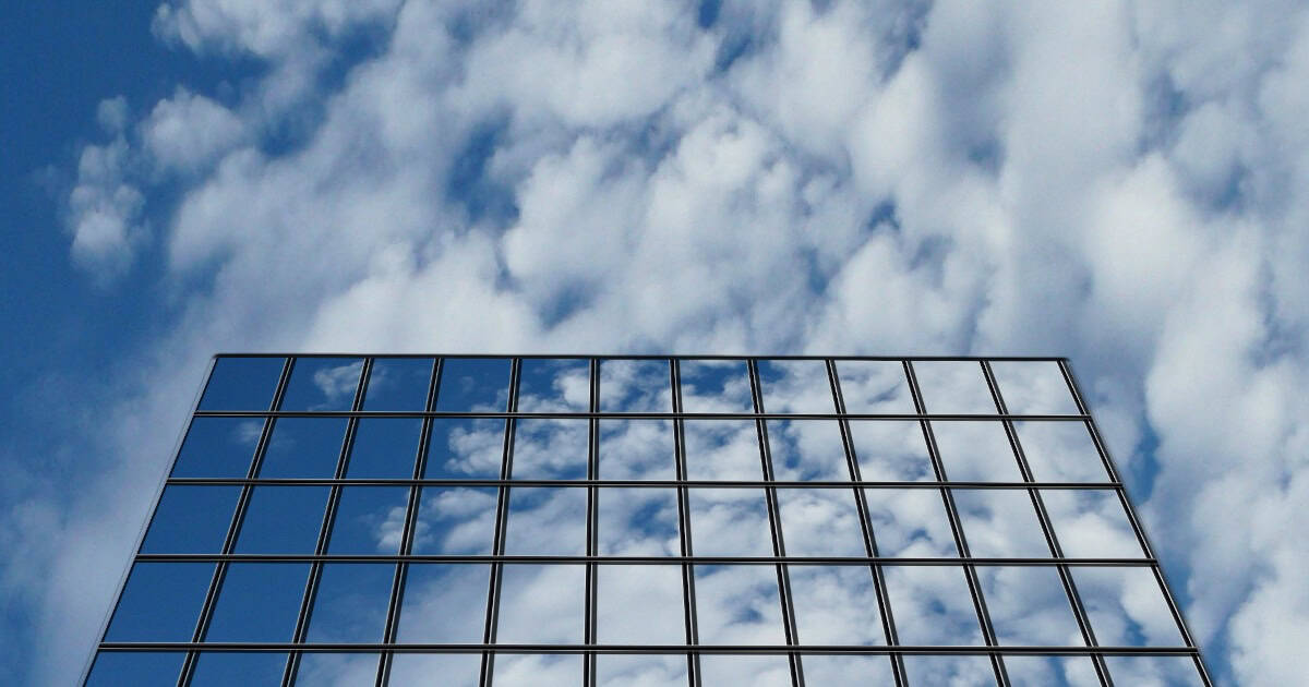 Clouds reflected in the glass facade of a modern building