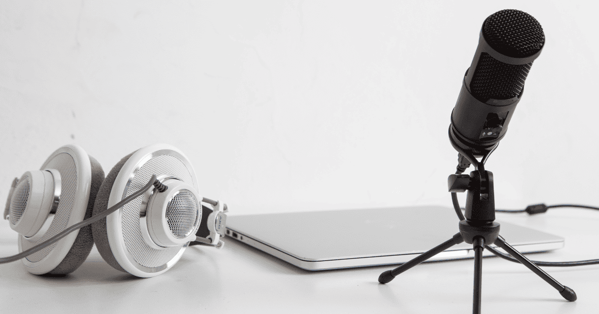 Headphones, a laptop and a microphone on a desk