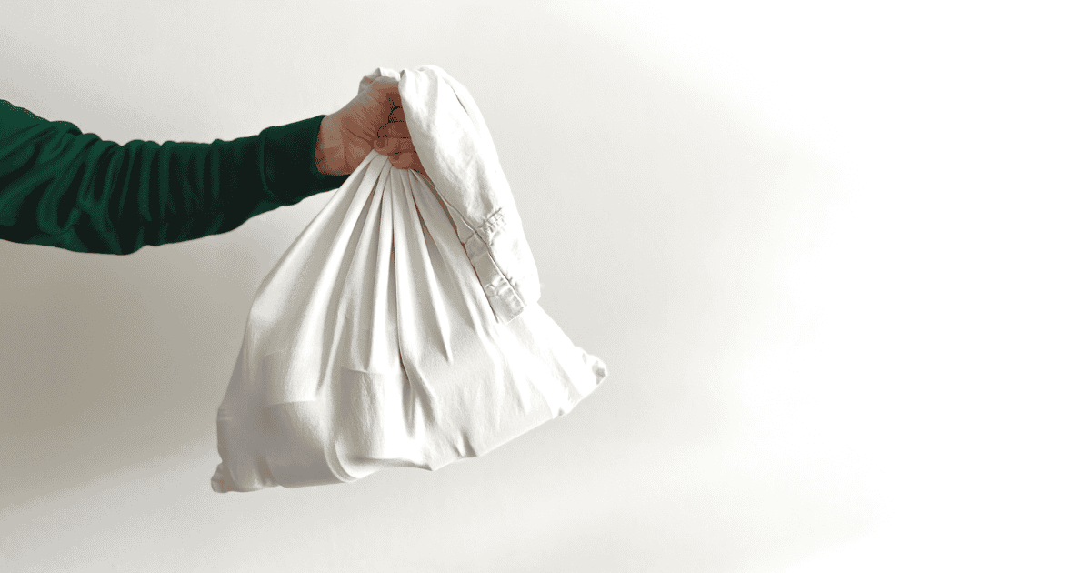 A hand holding a white cloth bundle